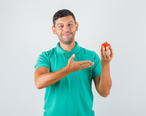 joven-mostrando-tomate-en-la-mano-en-camiseta-verdosa-y-mirando-feliz.jpg